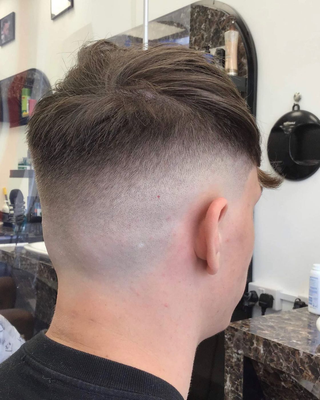 Skin fade blended to a textured top, viewed from behind